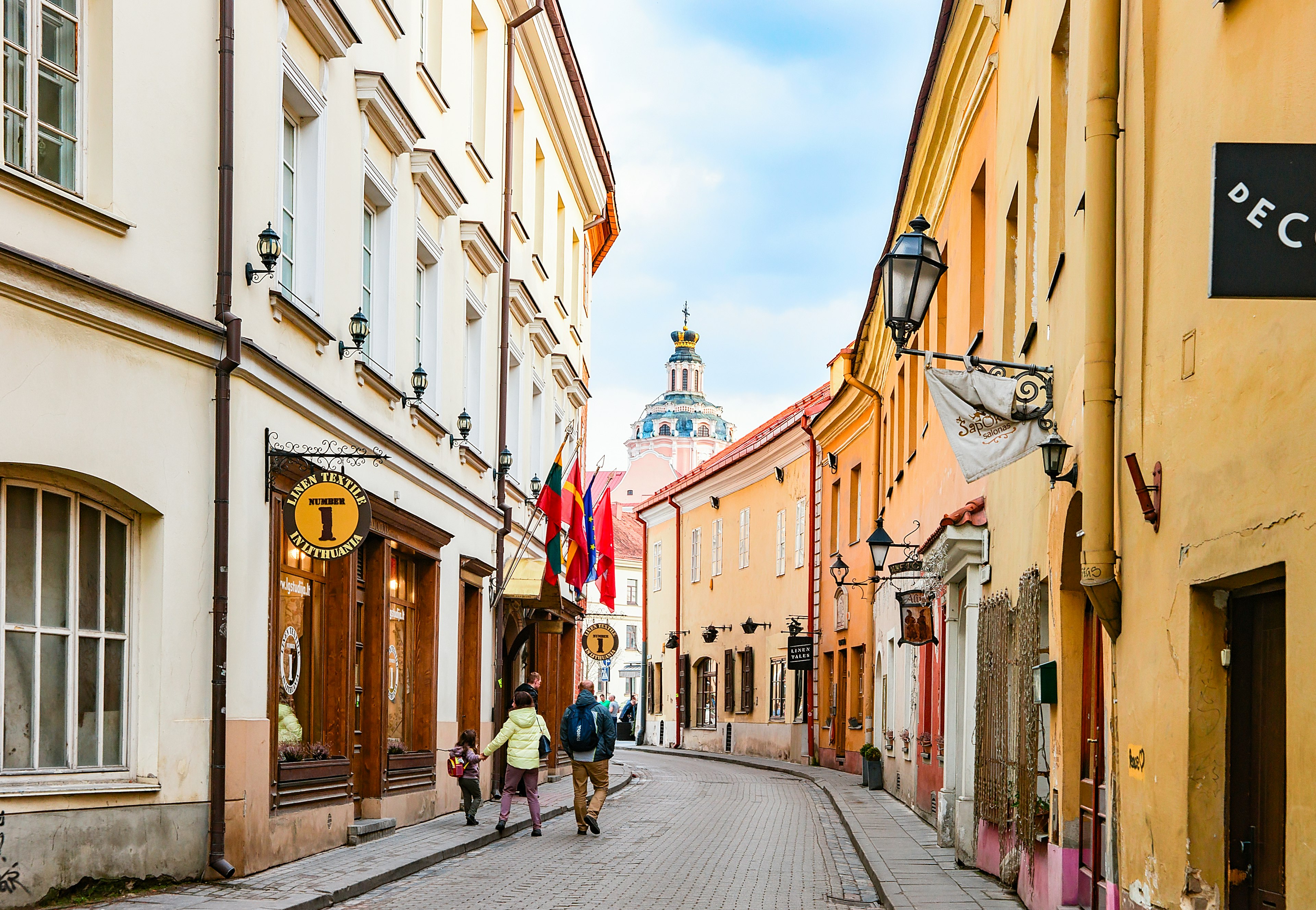 Tourists walk down a narrow street in the Old Town, Vilnius, Lithuania