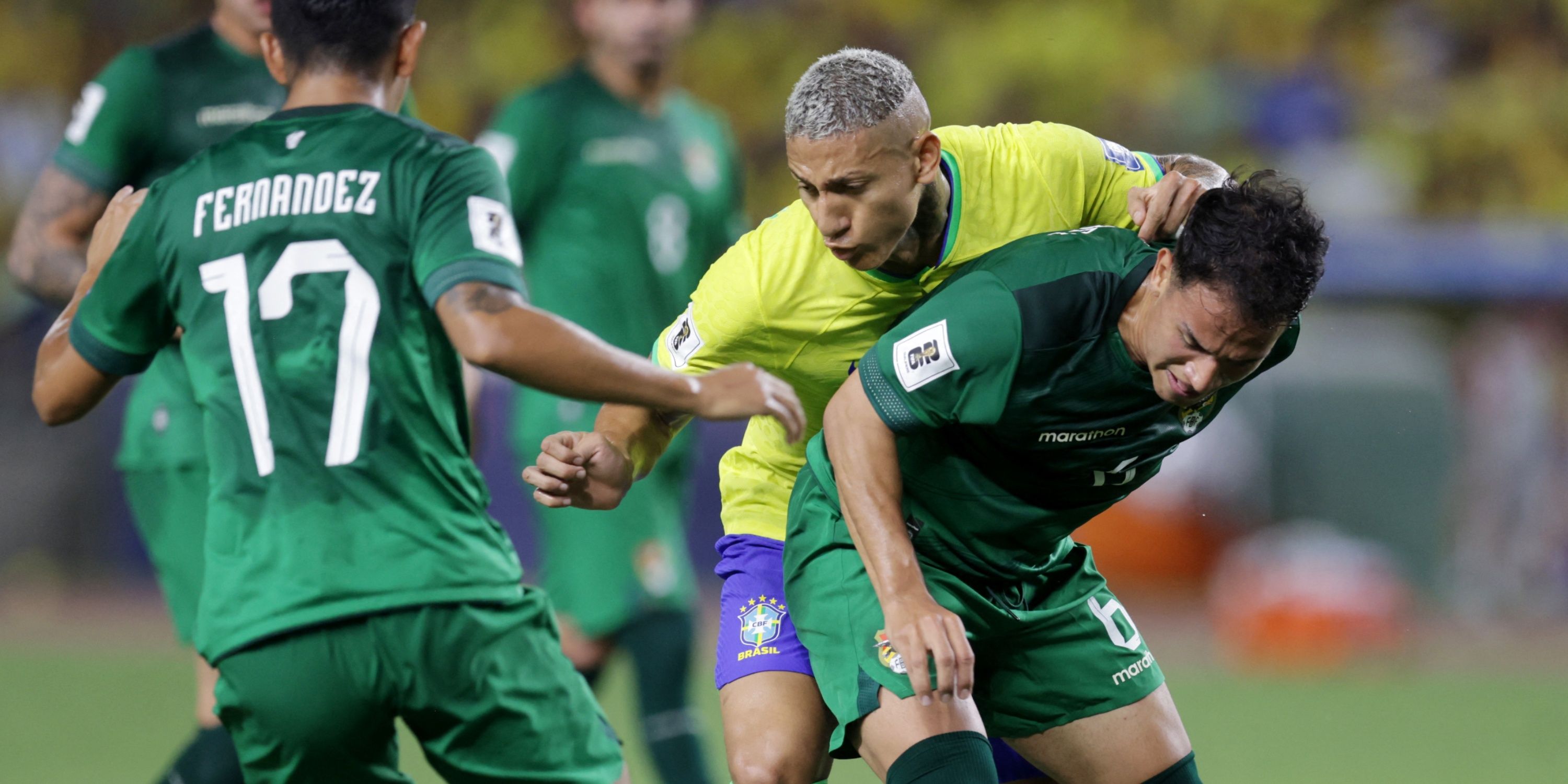 Richarlison battles for the ball with Bolivia players.