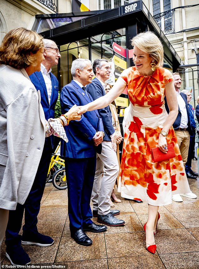 The mother-of-four opted for an orange and white floral summer dress which she paired with vibrant red stilettos