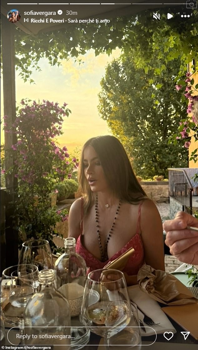 In this image she had on a plunging red dress and rosary as she dined al fresco