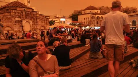 EPA People stroll while African dust covers the sky of Athens, Greece