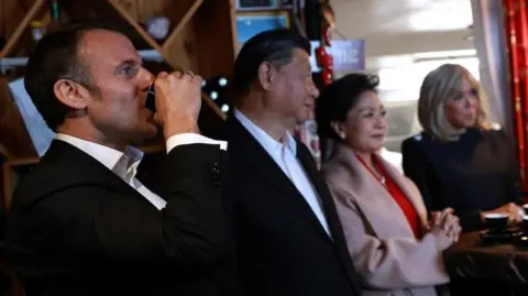 Reuters/Aurélien Morissard French President Emmanuel Macron drinks coffee in a restaurant with Chinese President Xi Jinping, his wife Peng Liyuan, and Brigitte Macron, on Tuesday, May 7, 2024, at the Tourmalet pass, in the Pyrenees mountains