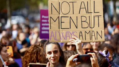 ABDUL SABOOR/REUTERS A woman holds a placard during a protest in support of Gisèle Pelicot