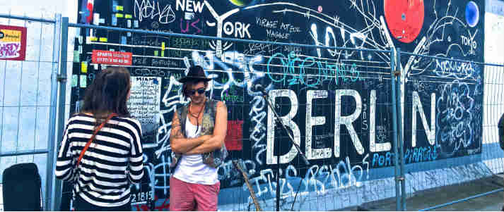 two people in front of berlin wall