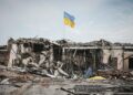 devastation under a Ukraine flag