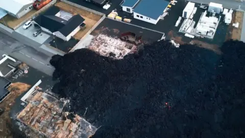 Getty Images Overhead photo of blackened lava after recently erupted volcano burns down three houses in the town on January 15, 2024