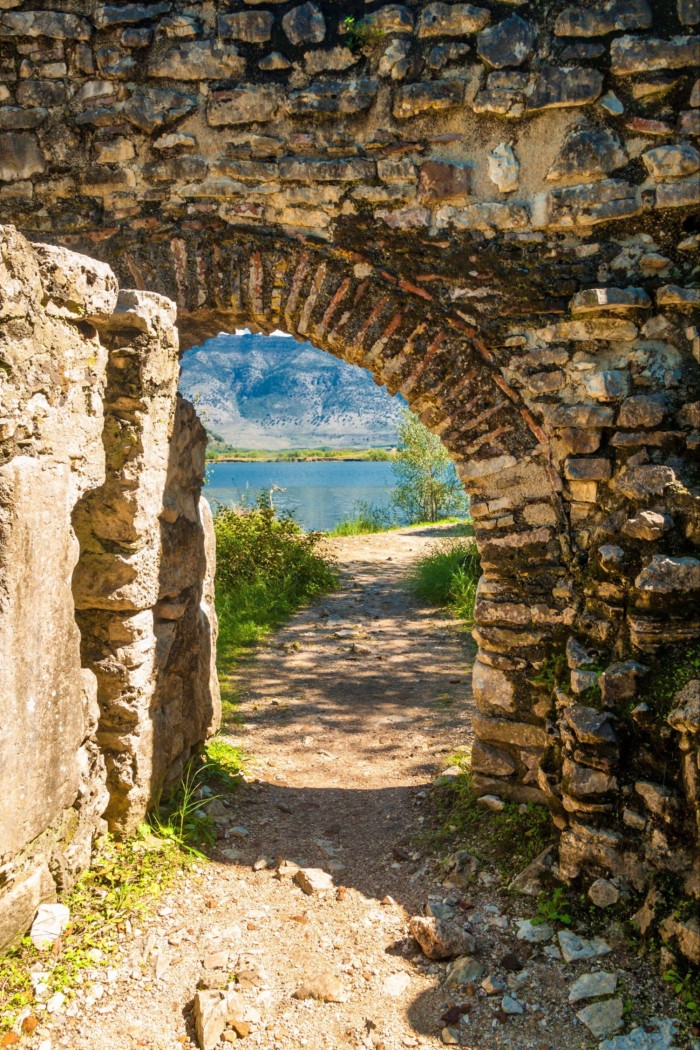 A view of a blue lake, seen through a brick arch