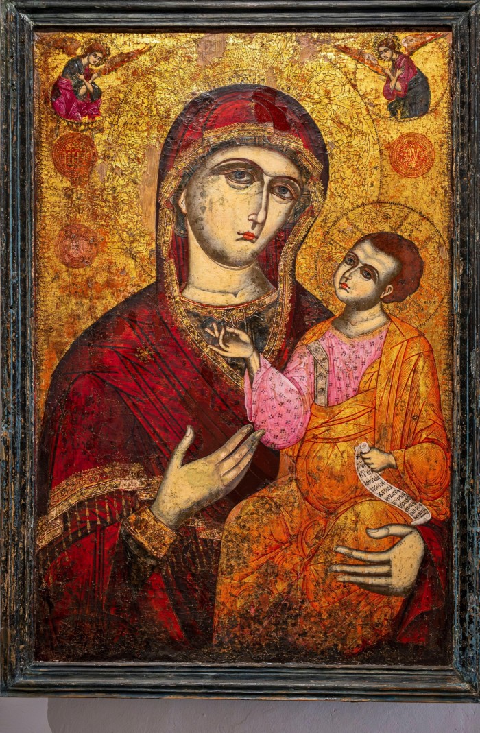 A painting in red and gold of the Virgin and child