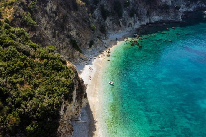 A view down over cliffs to a sandy beach and blue sea