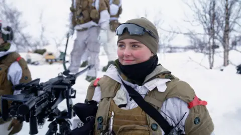 Elisabeth stands in uniform in the snow