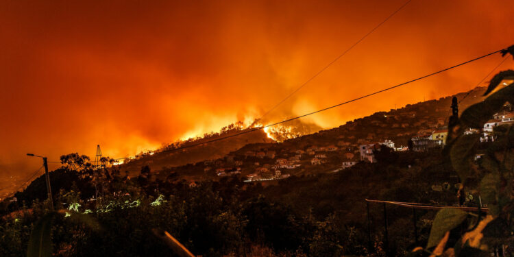 Wildfires over the crest of a hill