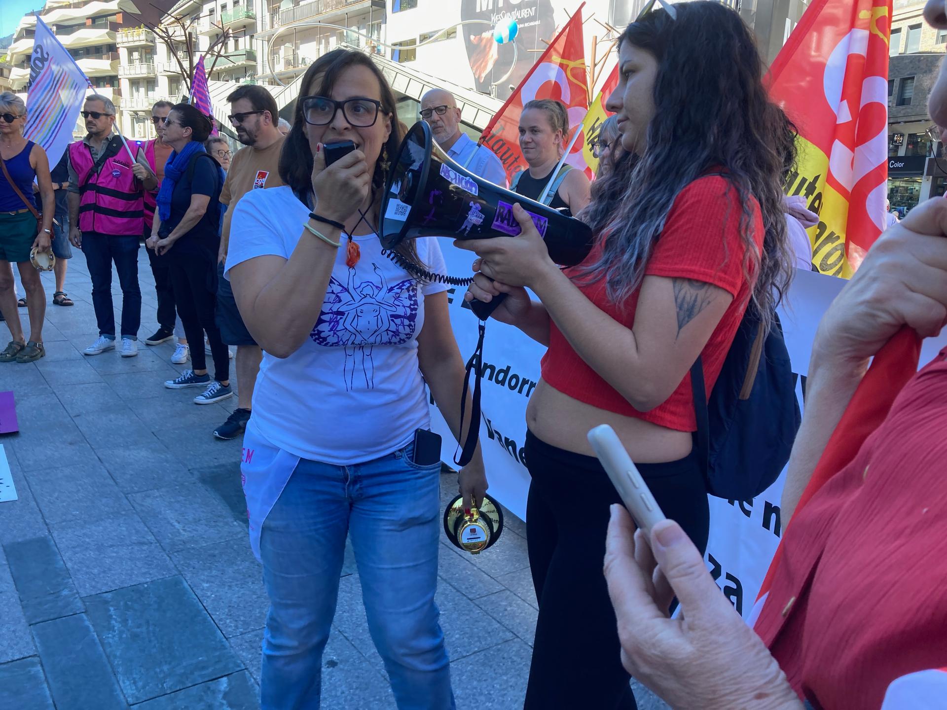 Two women talking to each other amongst a crowd of people