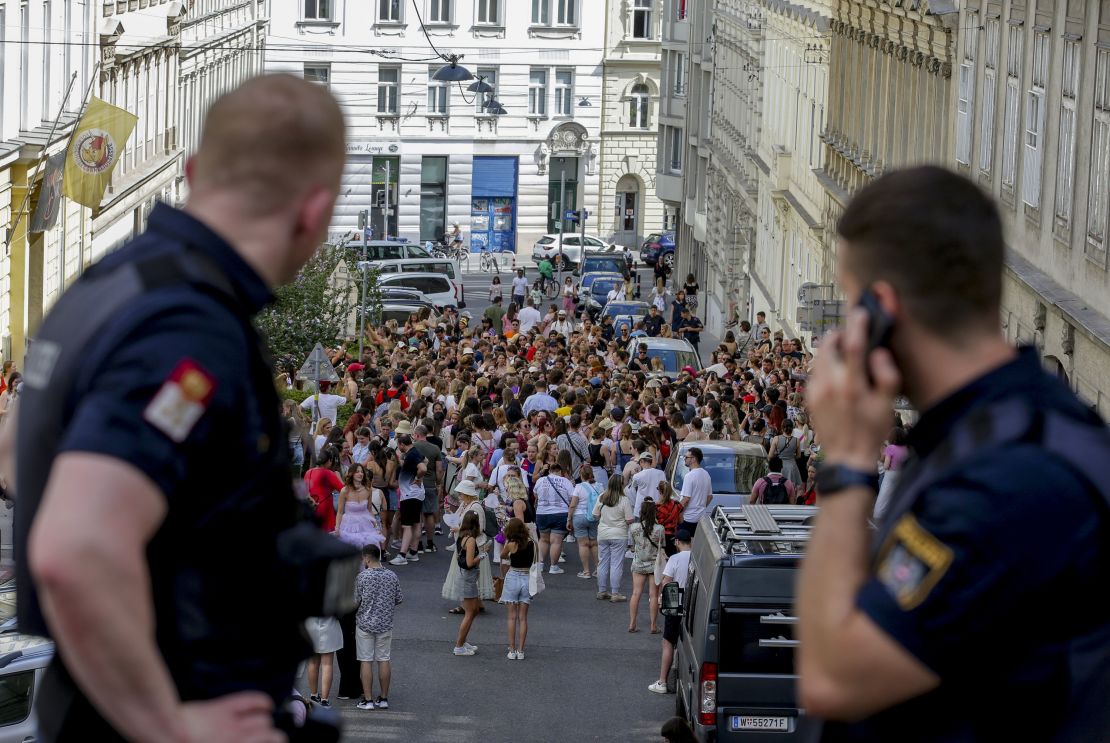 Austrian police officers watch Taylor Swift fans gather in Vienna, on August 8, after officials canceled the Austrian leg of the Eras Tour over a suspected terror plot.