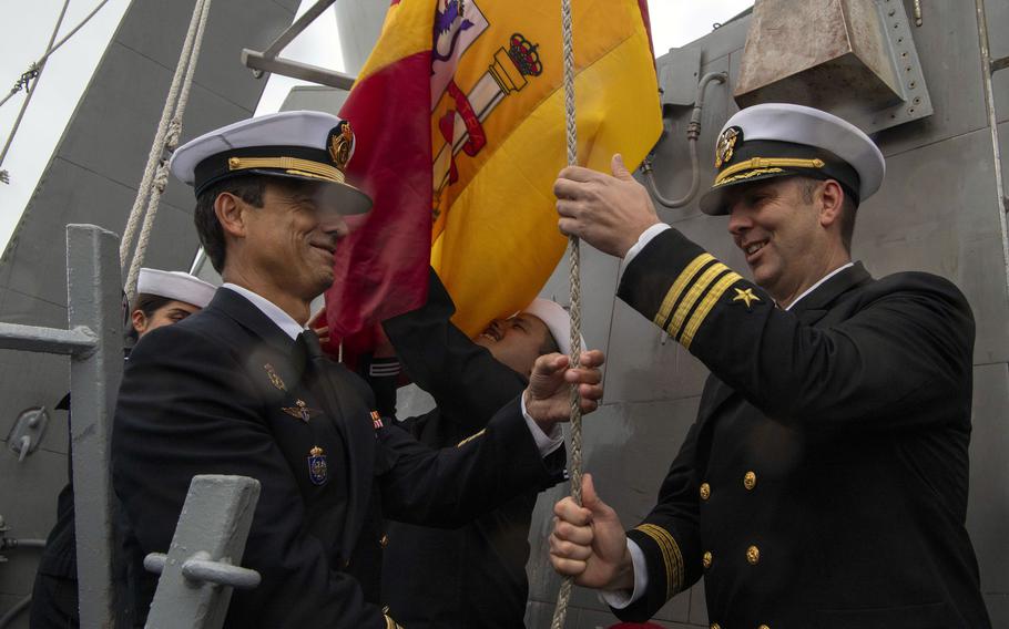 Cmdr. Scott Burrill, right, the commanding officer of the destroyer USS Oscar Austin, raises a Spanish flag with Spanish navy Capt. Ernesto Guesos, commander of the 41st Frigate Squadron, after the completion of the ship's homeport shift to Naval Station Rota, Spain, from Norfolk, Va., Oct. 15, 2024. 