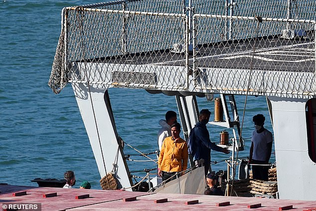 Migrants stand on the Italian navy ship Libra that arrived in Albania as part of a deal with Italy to process thousands of asylum seekers caught near Italian waters