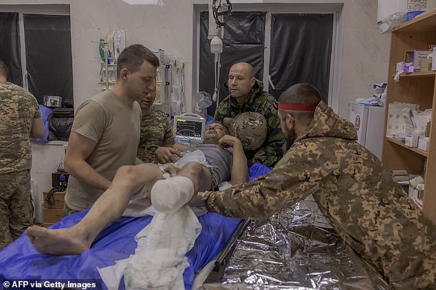 A Ukrainian wounded serviceman who was brought back from positions is being treated by Ukrainian military doctors is prepared to be transported to a hospital, at a stabilisation point of the 33rd Mechanised Brigade, near the Kurakhove town's frontline, in the eastern Donetsk region, early on October 14, 2024