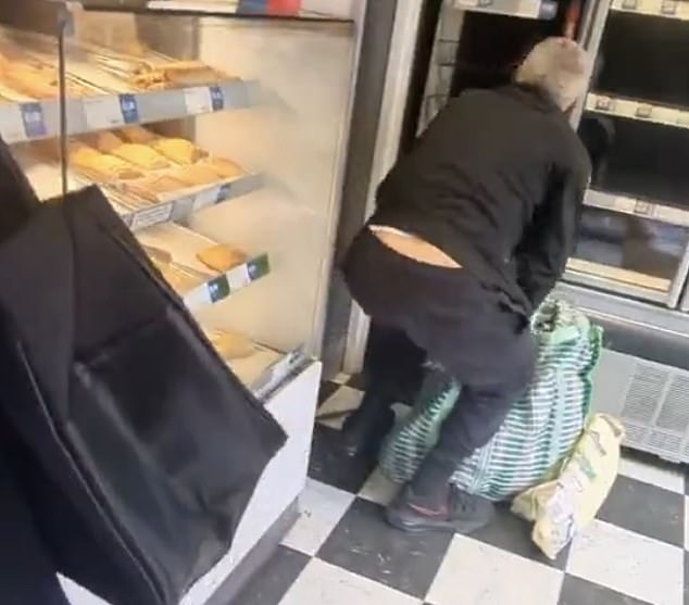 A shoplifter empties the shelves of a Greggs store in south east London into a giant holdall last month