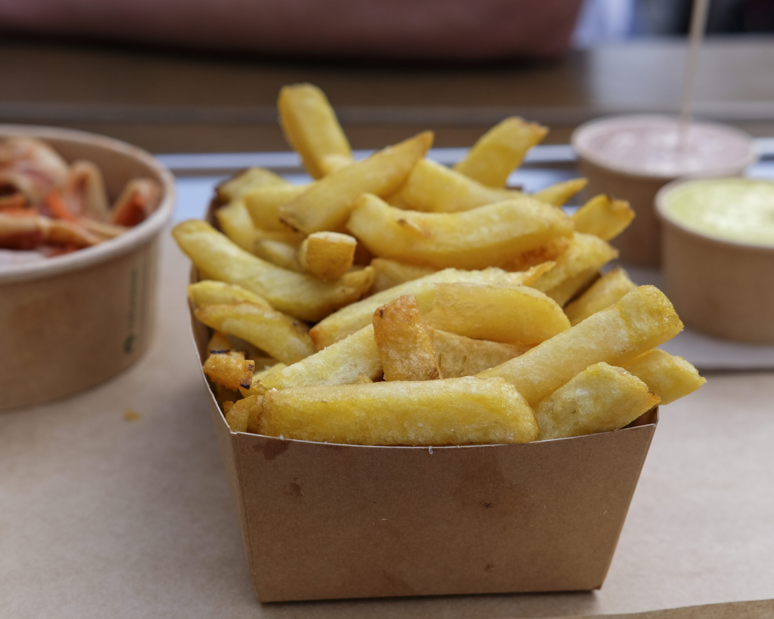 Fries, or frites, accompany most meals in Belgium. These fries from a specialty shop are served with flavored sauces and kimchi. Photo by Mahvish S. Khan