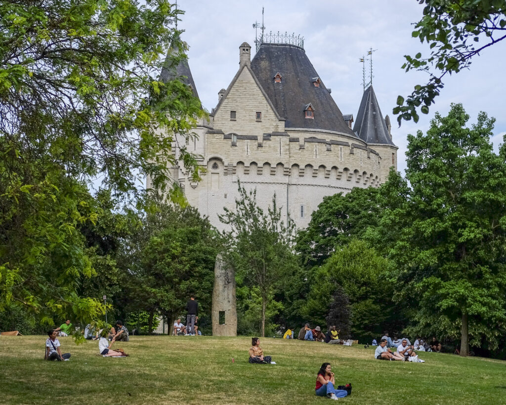 Picnickers sit on a hillside next to the Halle Gate, a former medieval city gate and the last vestige of the second walls of Brussels. Photo by Mahvish S. Khan