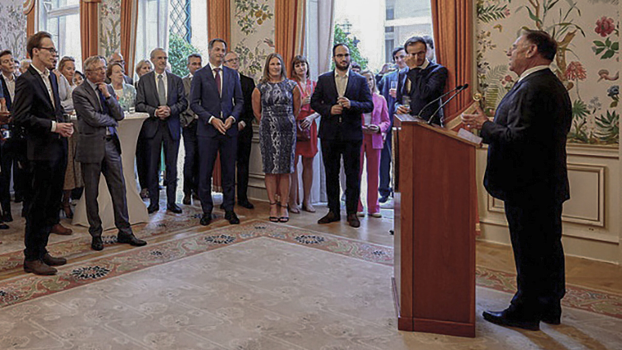 Fulbright alumnus Prime Minister Alexander De Croo (front row, fourth from left, in blue suit) listens to Ambassador Michael Adler deliver remarks at a Fulbright reception held at Whitlock Hall, June 15, 2022. Photo by Serge Vandendriessche