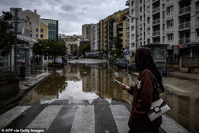 A local resident looks at a flooded street following heavy rainfall in Annonay, central France today