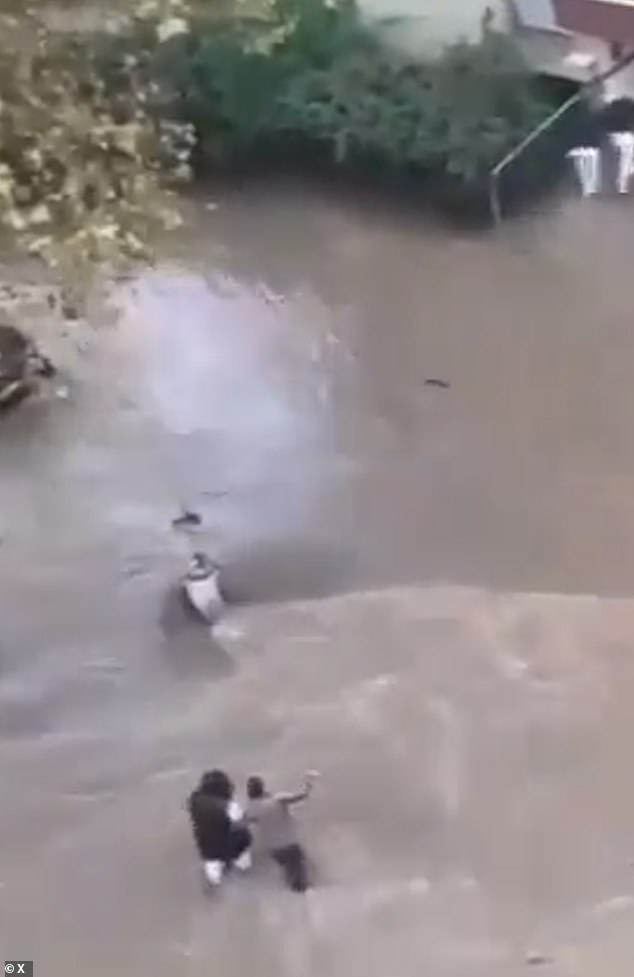Videos show people knee-deep in water struggling through the currents