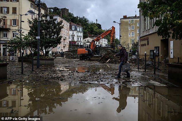 A local resident walks down a flooded street following heavy rainfall