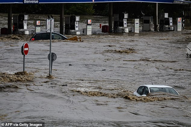 Image shows cars submerged in a commercial zone on October 16, 2024, in Givors, central-eastern France, following heavy rainfall in the area, which is under a red alert for rain and flooding