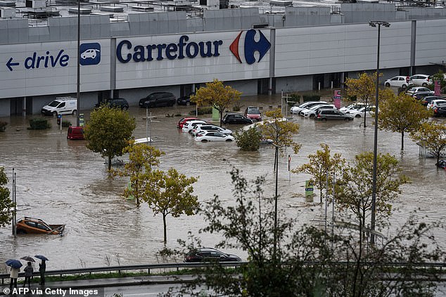 Partially submerged cars parked in a shopping center parking lot in Givors pictured today following flooding
