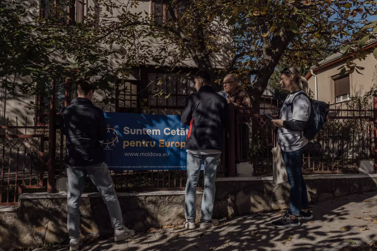 Volunteers from the organization Citizens for Europe hang up a banner on the fence of a local residence about the upcoming European Union referendum, in Rîşcani, Moldova, Oct. 13.