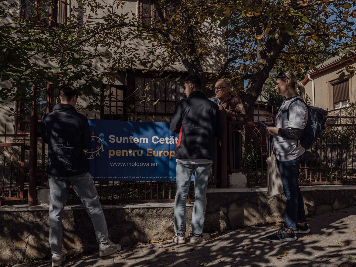 Volunteers from the organization Citizens for Europe hang up a banner on the fence of a local residence about the upcoming European Union referendum, in Rîşcani, Moldova, Oct. 13.