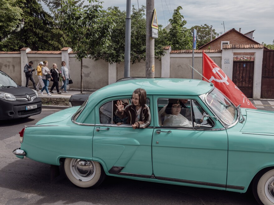 A girl waved out the window of a car during a Victory Day parade in Chișinău, Moldova, May 9. Many from Moldova’s Russian-speaking population remain nostalgic for the days of the former Soviet Union.