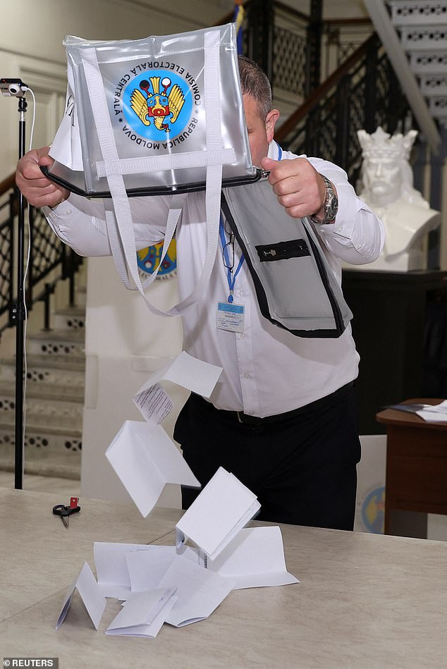 A member of an electoral commission empties a ballot box after polling stations closed in the course of Moldova's presidential election and a referendum on joining the European Union, in Chisinau, Moldova October 20, 2024