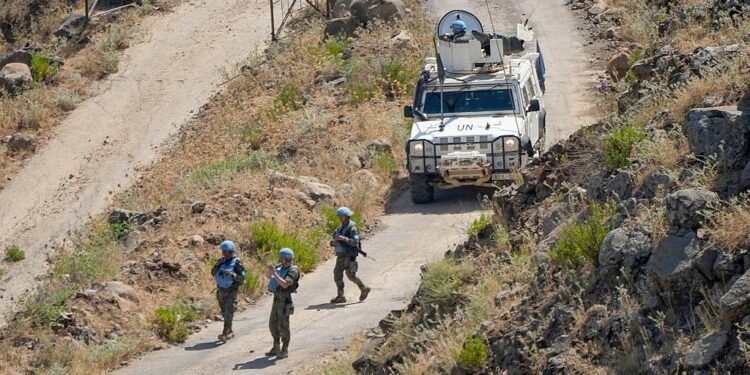 Lebanese soldiers stand behind a damaged vehicle after a UN peacekeepers convoy came under fire in the Al-Aqbiya village, south Lebanon, Thursday, Dec. 15, 2022.