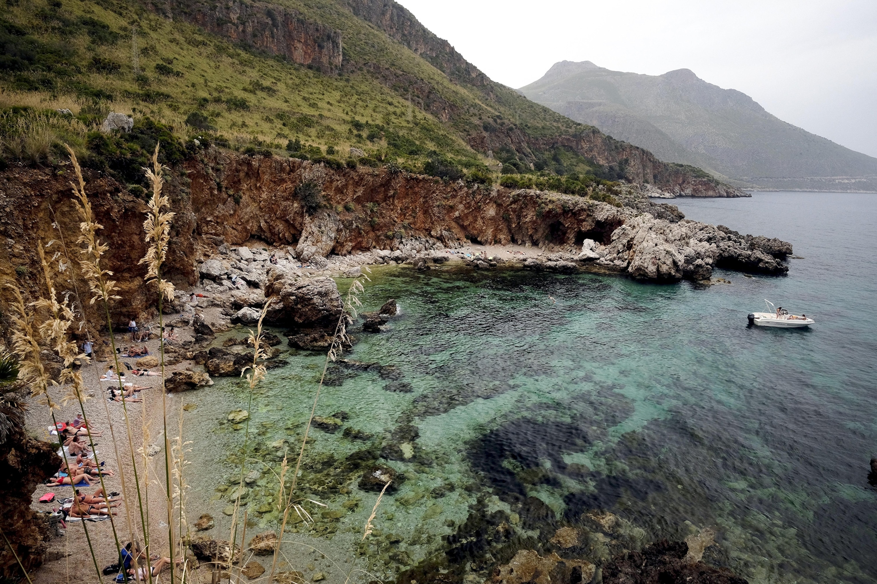 People relax on a beach in the Zingaro nature reserve.