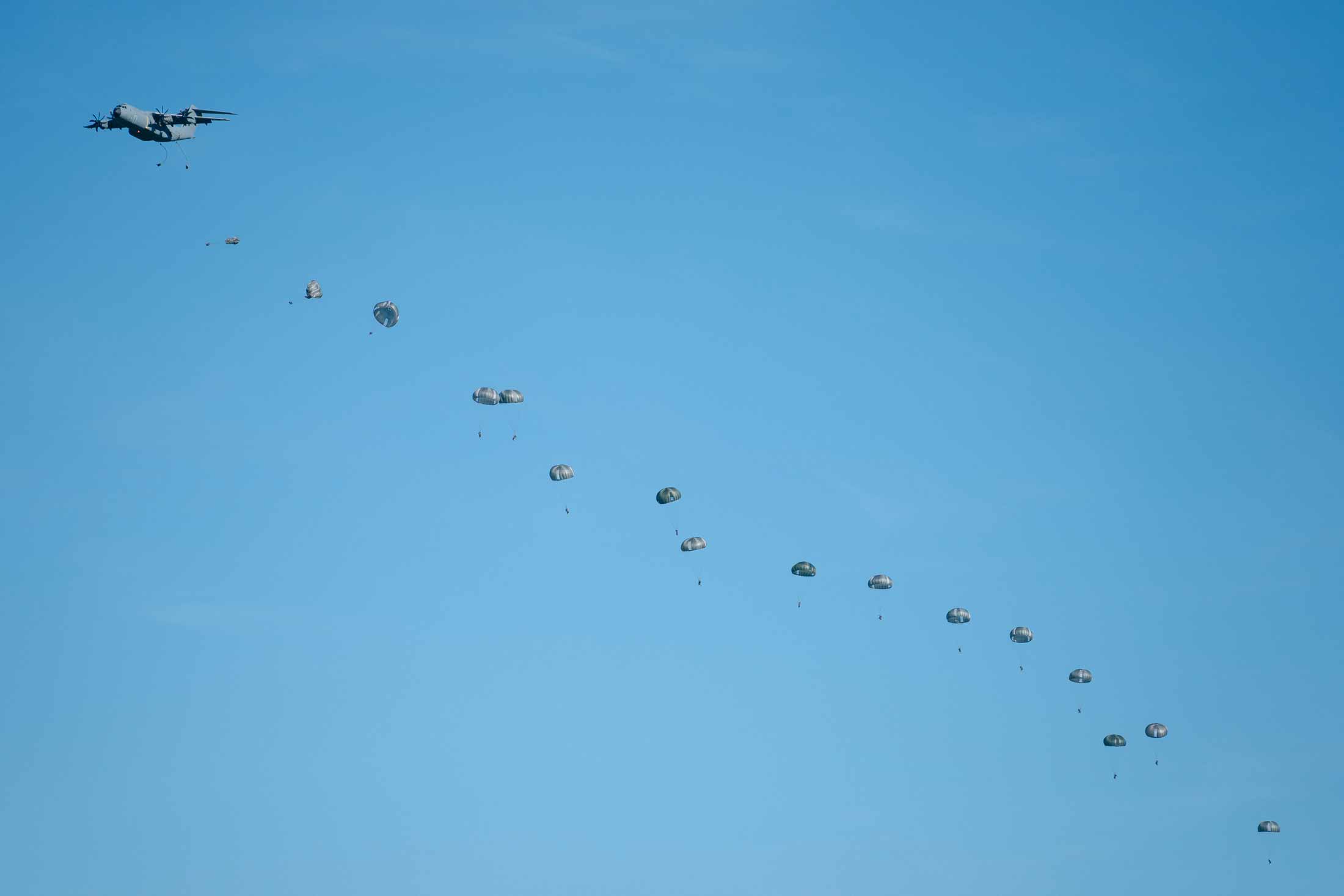 Spanish paratroopers descend during the military exercise Swift Response at Campia Turzii, Romania. Photographer: Andrei Pungovschi/Bloomberg