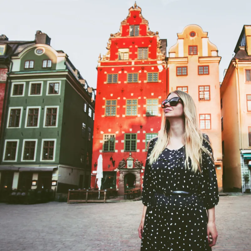solo female traveler wandering around a colorful square in stockholm sweden