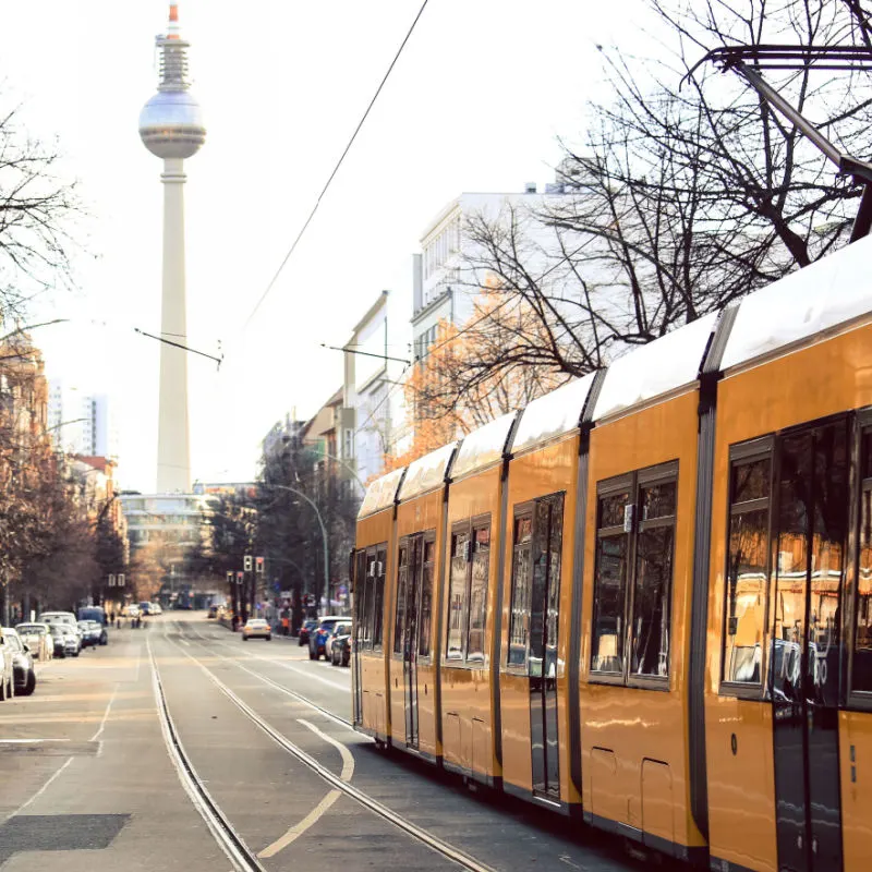 A yellow tram runs through the streets of Berlin, Germany