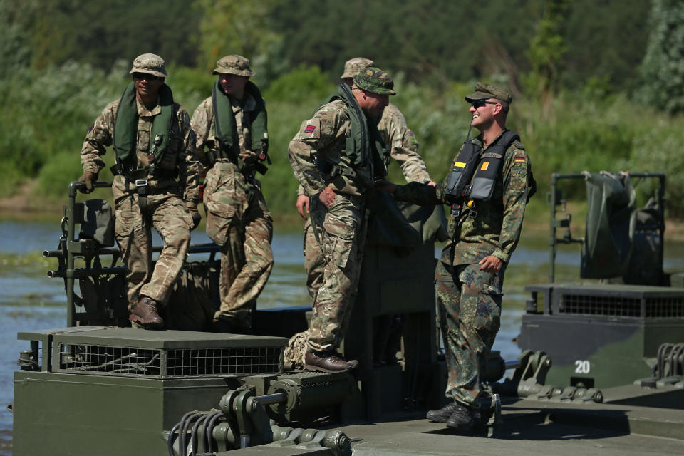 ZAPYSKIS, LITHUANIA - JUNE 08: A German soldier of the Bundeswehr (R) chats with British Royal Engineers at a joint operation at the Neman River during Saber Strike 2018 military exercises on June 8, 2018 in Zapyskis, Lithuania. Two NATO exercises: Thunder Storm 2018, which is being hosted and led by Lithuania, and Saber Strike 2018, which is being held across the three Baltic nations and is led by the United States Army, are coinciding this week and will run until mid-June. NATO, in an initiative called enhanced Forward Presence (eFP) first launched in 2017, maintains multinational NATO battalions in Poland, Lithuania, Latvia and Estonia as a defensive deterrent against Russia. (Photo by Sean Gallup/Getty Images)