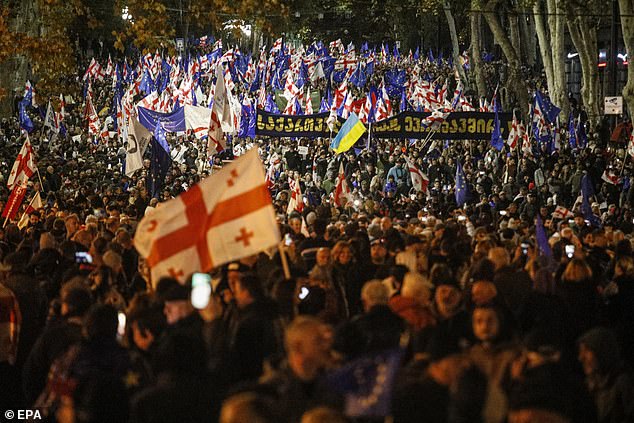 People wave EU and Georgian flags as they participate in a pro-Europe rally ahead of the parliamentary elections in Tbilisi, Georgia