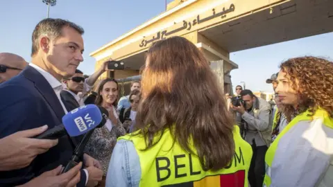 NICOLAS MAETERLINCK/BELGA MAG/AFP  Prime Minister Alexander De Croo talks to Belgian social workers in support for Belgian citizens crossing the border during a visit to the city of Rafah, in the southern Gaza Strip in the State of Palestine, Friday 24 November 2023