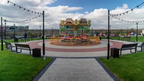 Matthew Goddard A picture of a small children's merry go round with cars in Gagauziyaland. The park looks very new, but there is hardly anyone there. It looks empty