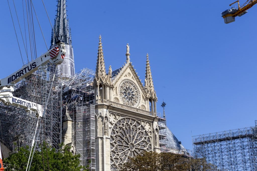 An exterior view of Notre Dame and construction cranes amid a reconstruction process