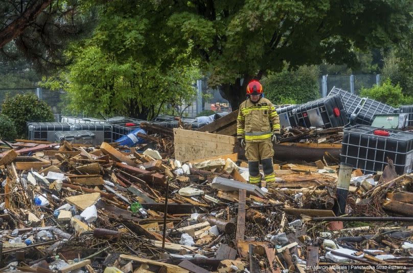 This handout photo provided by the Polish fire department, shows firefighters removing piles of debris dumped in the streets by high flood wave.