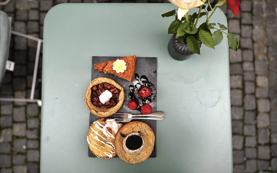 Large cookies and slices of cake are displayed on a table.