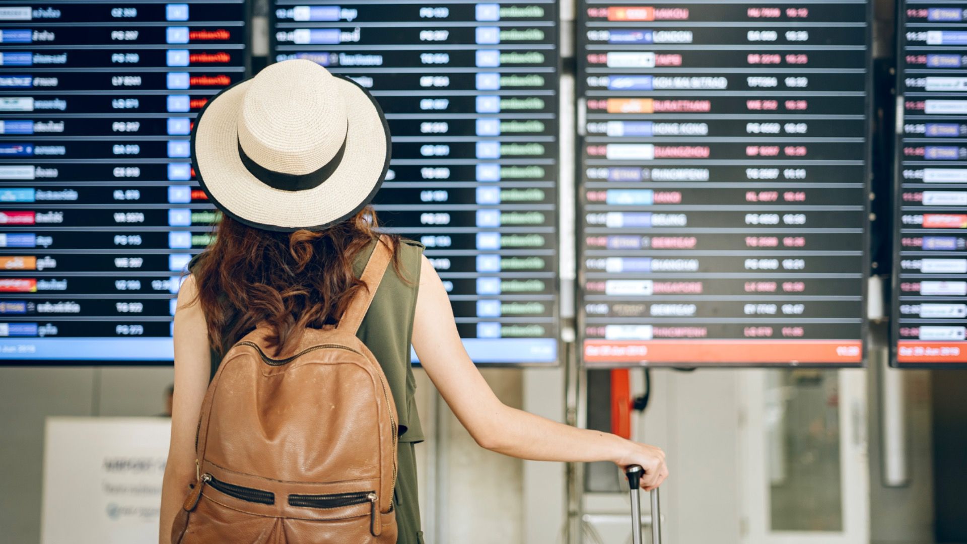 Woman staring at delayed flights at the airport