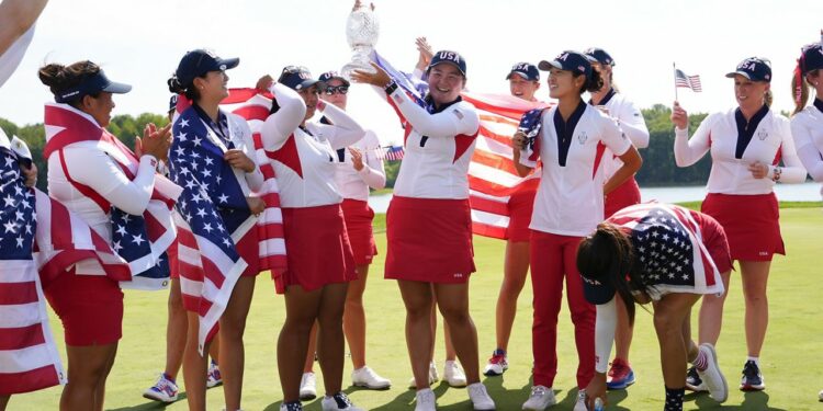 Punahou School graduate Allisen Corpuz, center, held the winner's trophy after the U.S. won the Solheim Cup over Europe at Robert Trent Jones Golf Club in Gainesville, Va., on Sunday.