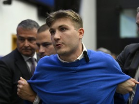 Security officers lead away a man, who disrupted the press conference of Hungarian Prime Minister Viktor Orban ahead of a plenary session at the European Parliament in Strasbourg, France, Tuesday, Oct. 8, 2024.