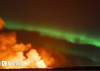 Iceland: Northern Lights captured glowing over erupting volcano – BBC.com