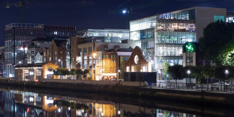 Skyline of the offices on the shoreline of the 'River Liffey' in Dublin illuminated at night.